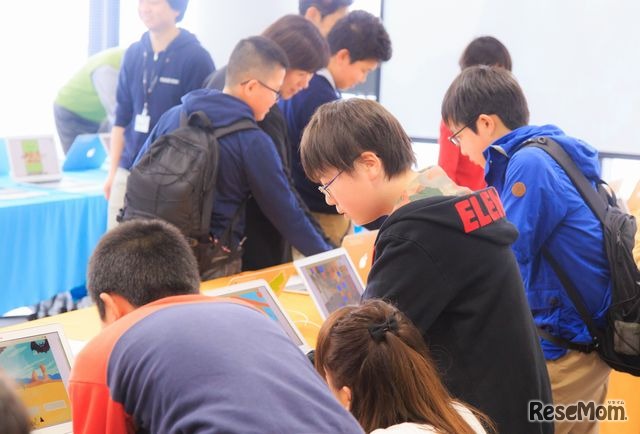 展示会場で他の生徒の作品を遊ぶ生徒